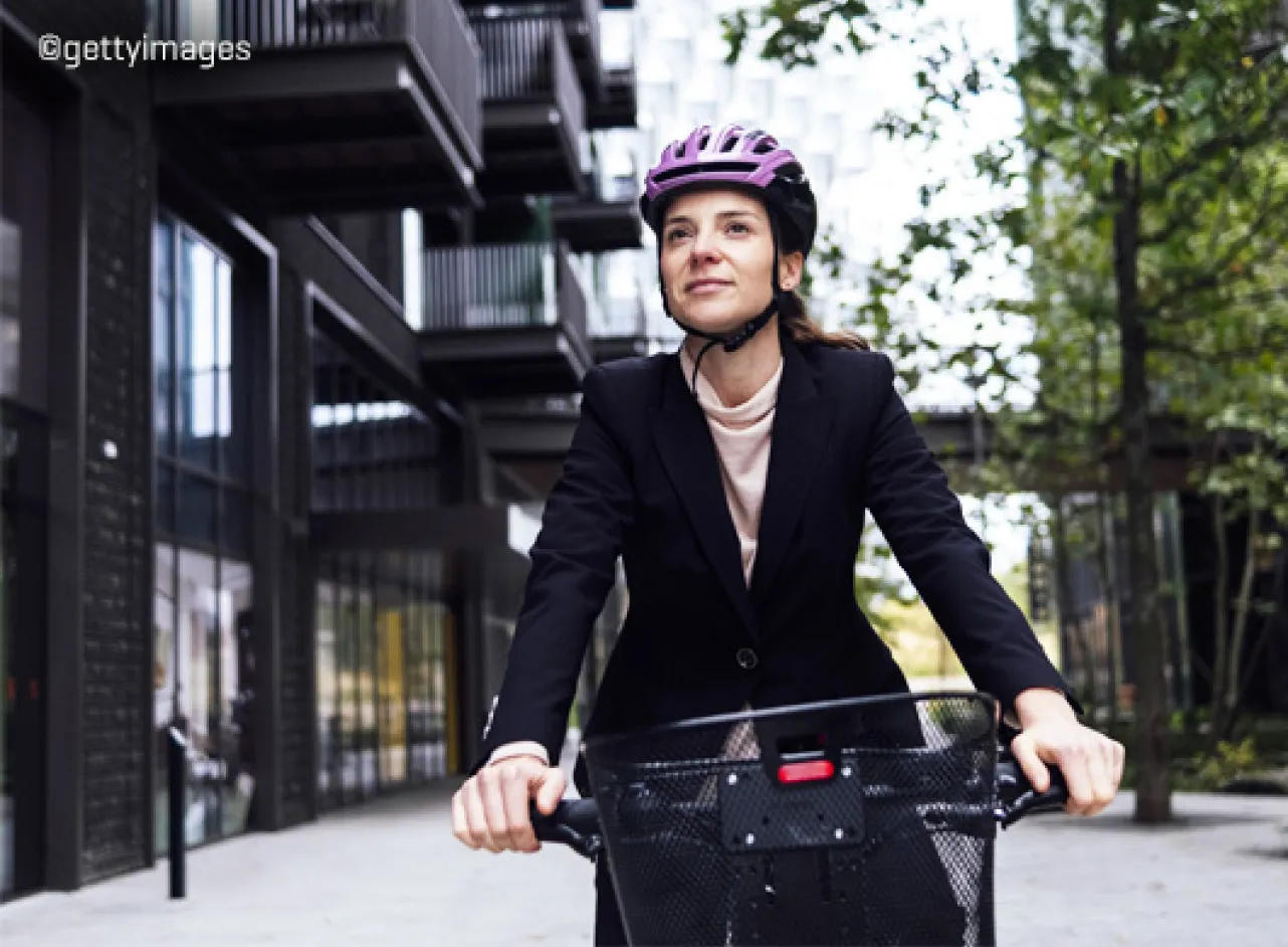 Vrouw op fiets met roze helm